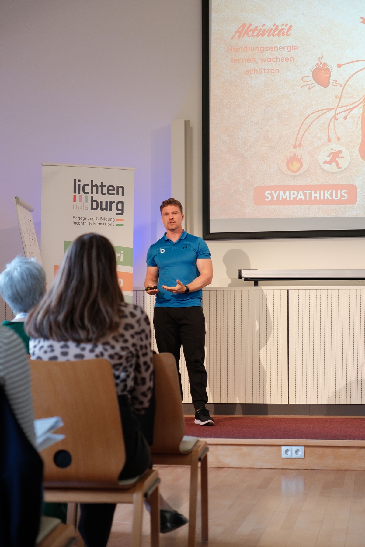 Fabian hält einen Vortrag zu Gesundheit am Arbeitsplatz vor Unternehmensvertreter:innen.