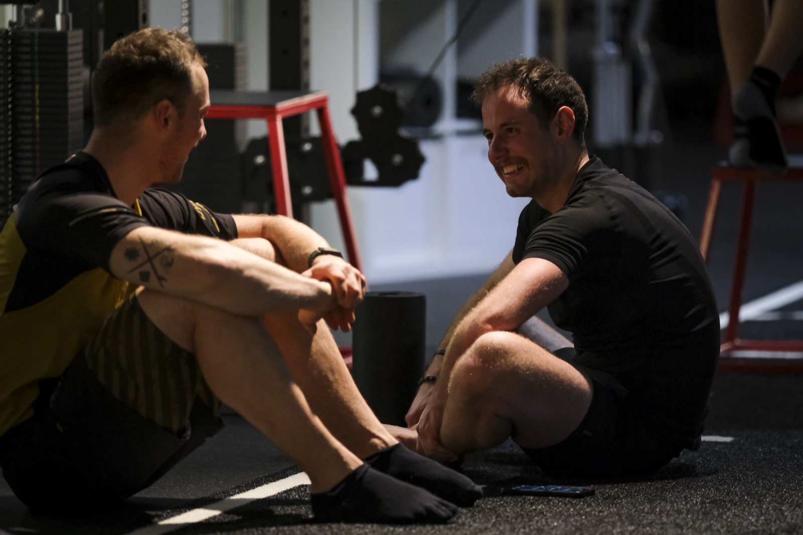 Zwei Coaches im entspannten, kollegialen Gespräch nach dem Training bei beyond.